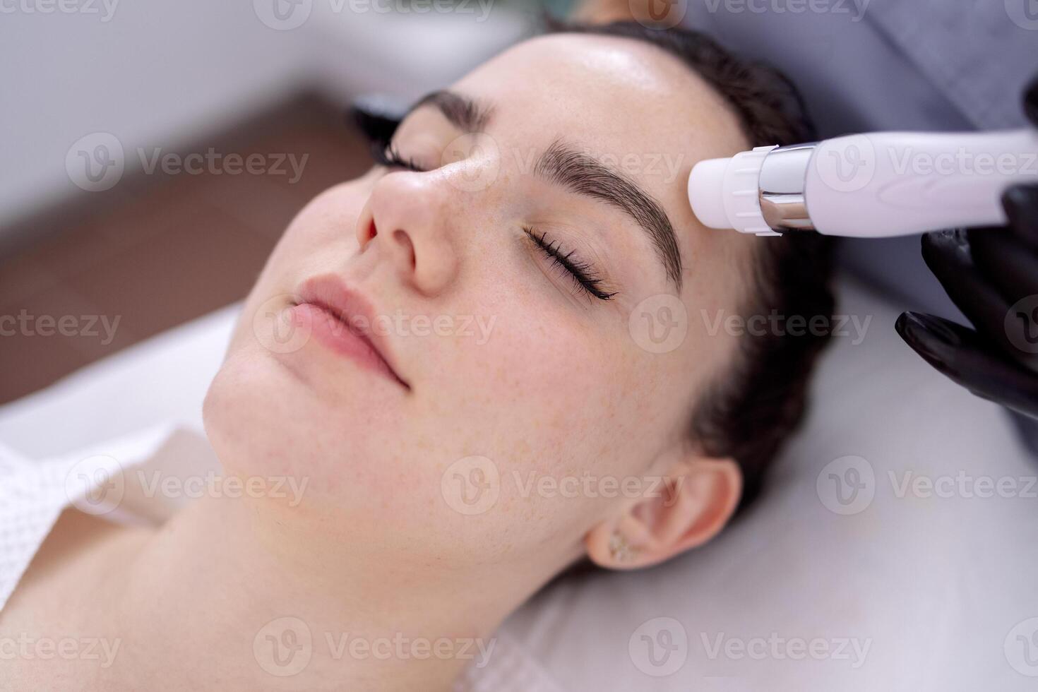 Young beautiful woman getting lifting anti-aging, face massage a photo