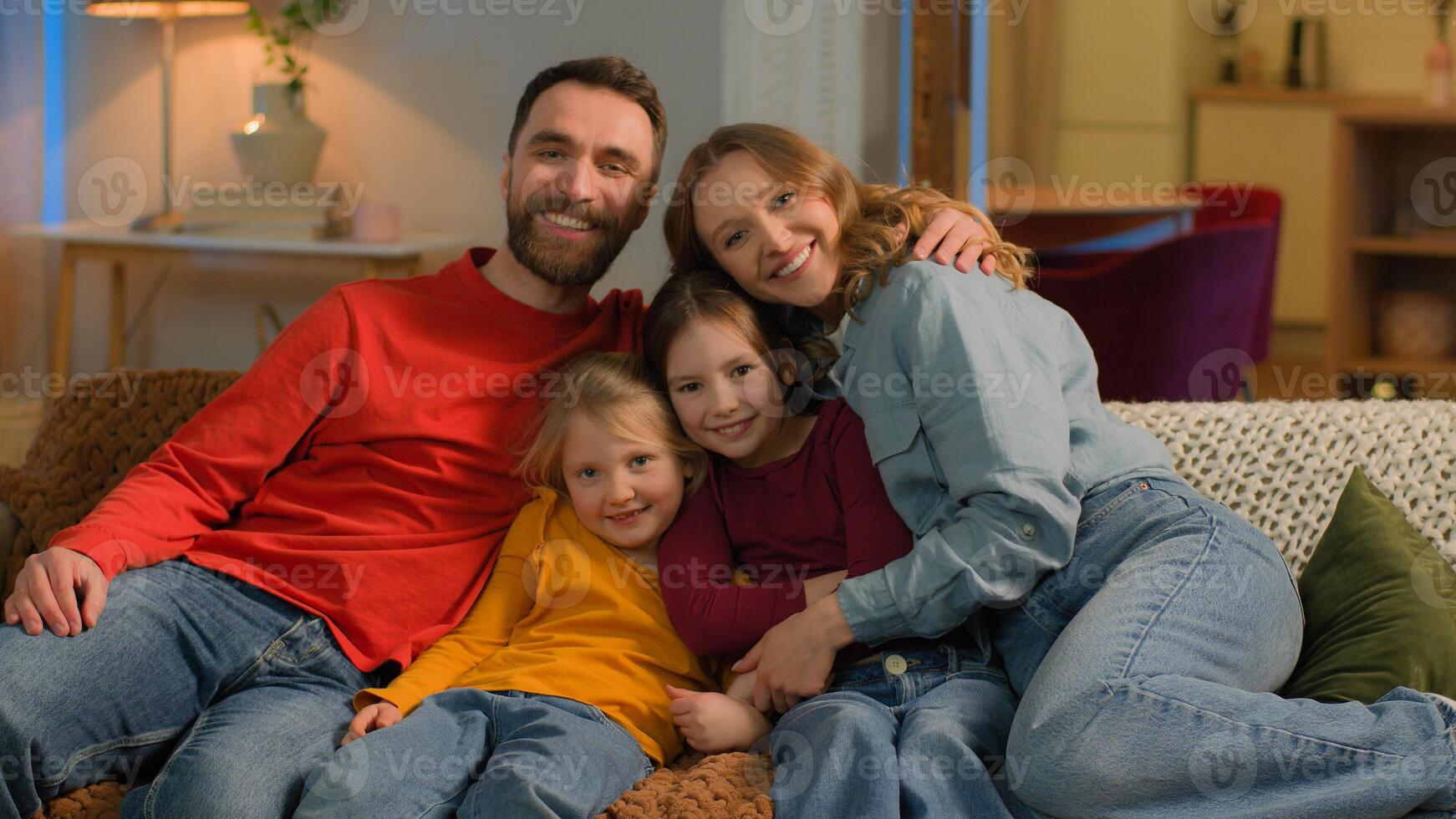 Caucasian happy carefree parents children jumping on sofa couch together family portrait affectionate mom dad little girls daughters kids laugh smile bonding weekend at home mortgage custody adoption photo