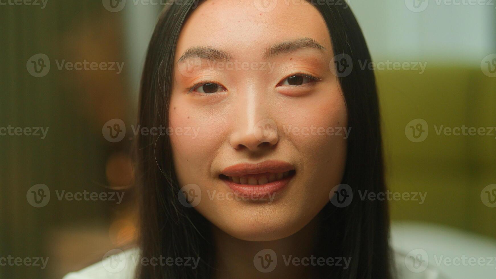 Close up face portrait Asian Japanese woman 20s gen z girl young student businesswoman lady Chinese Korean female customer Asia beauty happy emotions cheerful smile looking at camera headshot indoors photo