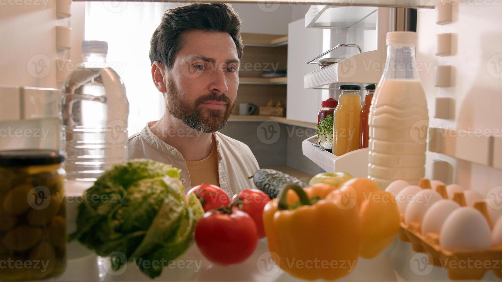 Point of view POV inside refrigerator Caucasian man husband guy male homeowner chef open fridge full of healthy fresh vegetables check ingredients checking meal at home kitchen planning food delivery photo