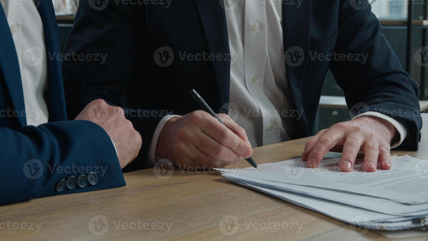 Close-up two unrecognizable businessmen men business partners signing contract document conclude successful financial deal at meeting in office sign for partnership cooperation shake hands handshake photo