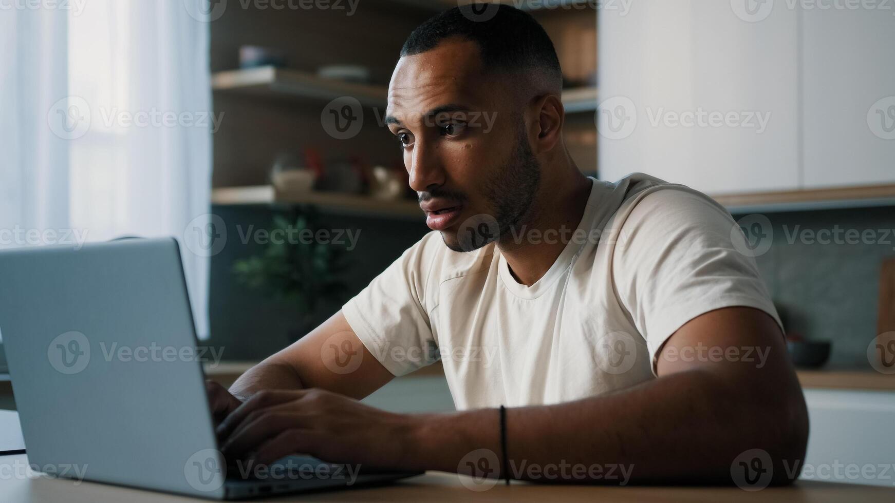 African ethnic male man at kitchen at home play online game bet losing betting bad result feel frustrated upset working problems business failure with laptop cryptocurrency crash mistake with computer photo