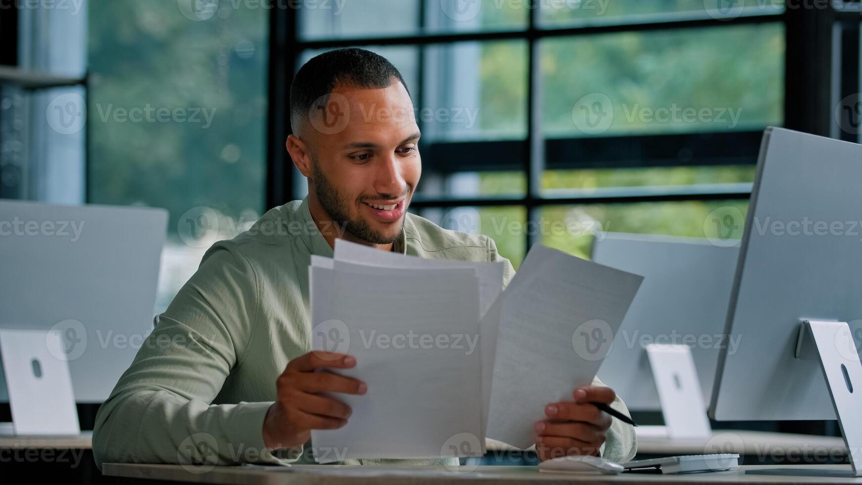 African man worker analyst accountant teacher banker boss leader businessman financial specialist checks business documents papers busy with paper work in office at table with computer signs report photo