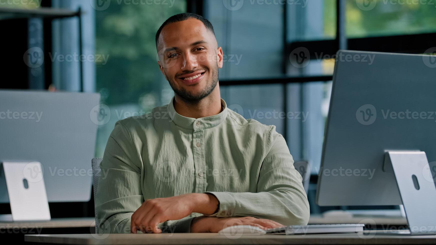 Happy smiling male investor multiracial worker developer programmer creative designer guy African American man with computer in office looking at camera smile sitting at table in company workplace photo