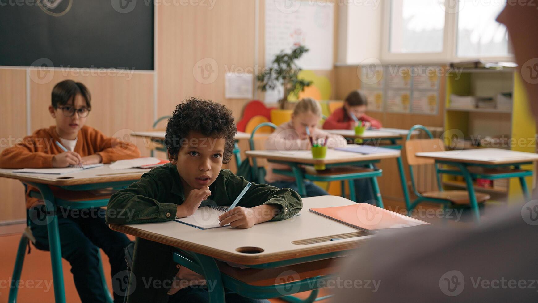 School class lesson group of multiracial diversity multiethnic children kids studying learning answer tutor writing task talking with unrecognizable woman teacher female teaching study learn education photo