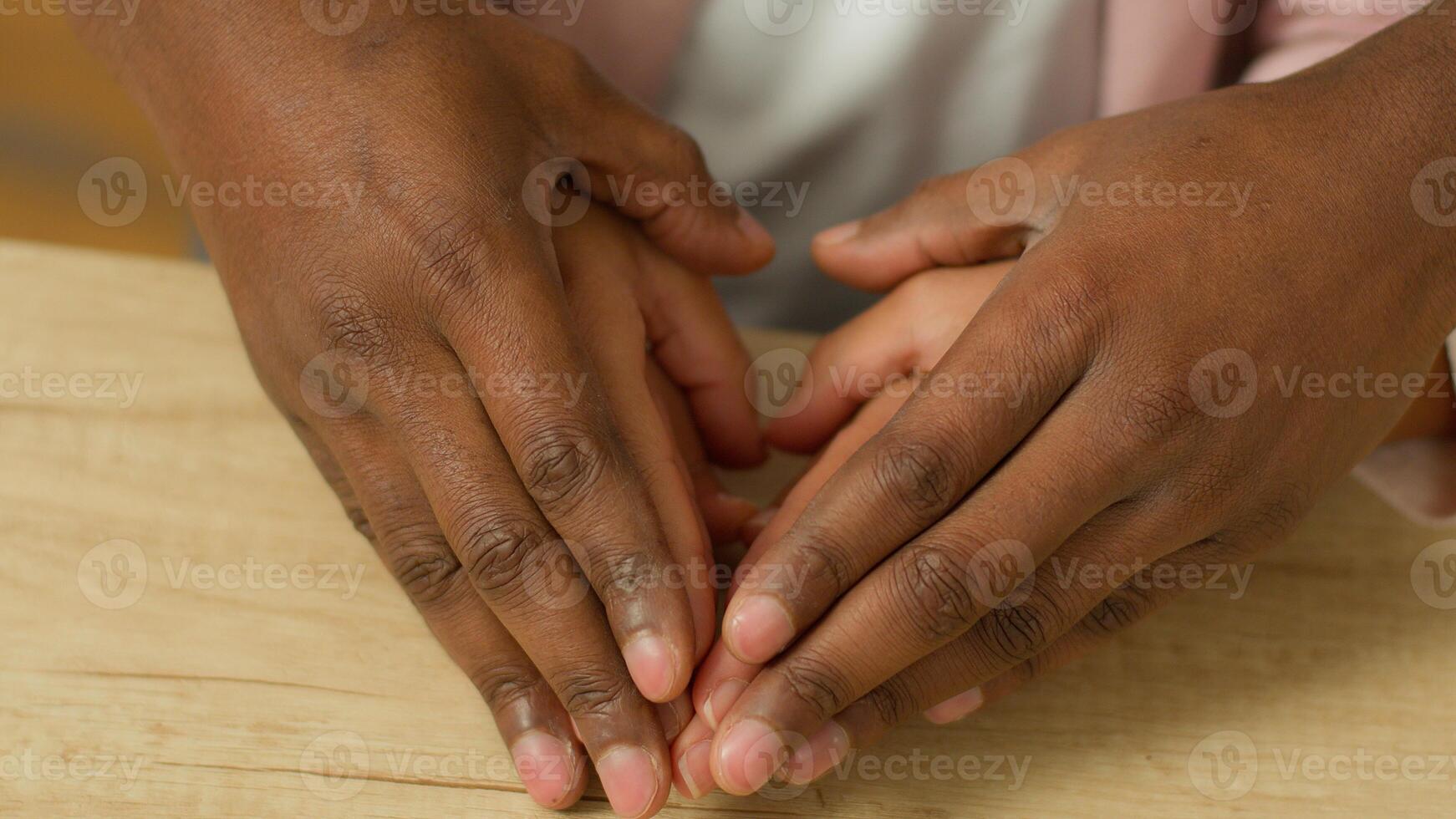 Close up family African people family hands on table at home rent loan insurance mortgage bonding custody adoption medicine childcare together child kid mother father connect arms heart cover safe photo