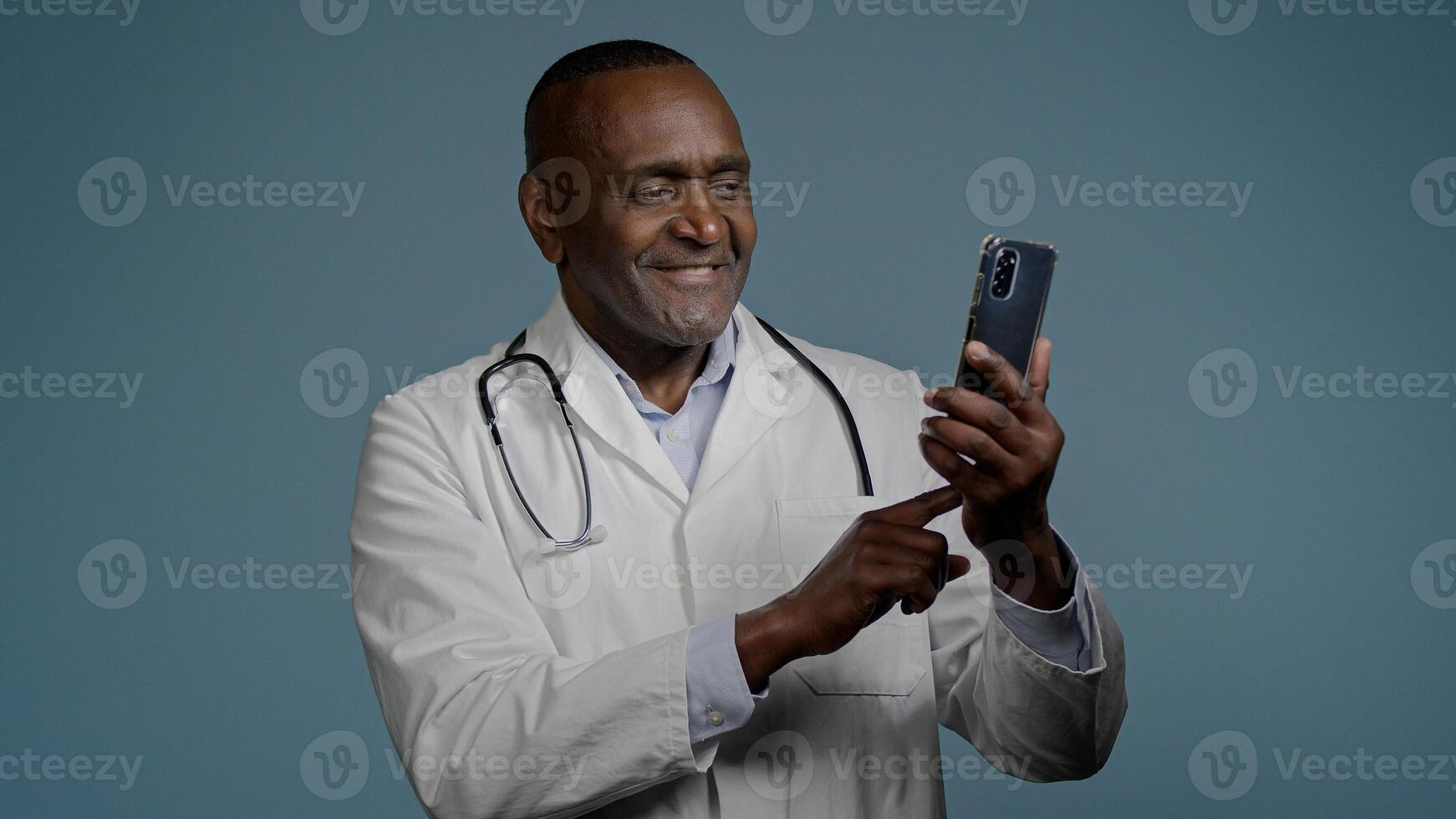 African American man male doctor in white uniform typing answer sending email message on smartphone browsing patient card using medical virtual application on mobile phone medicine and modern tech photo