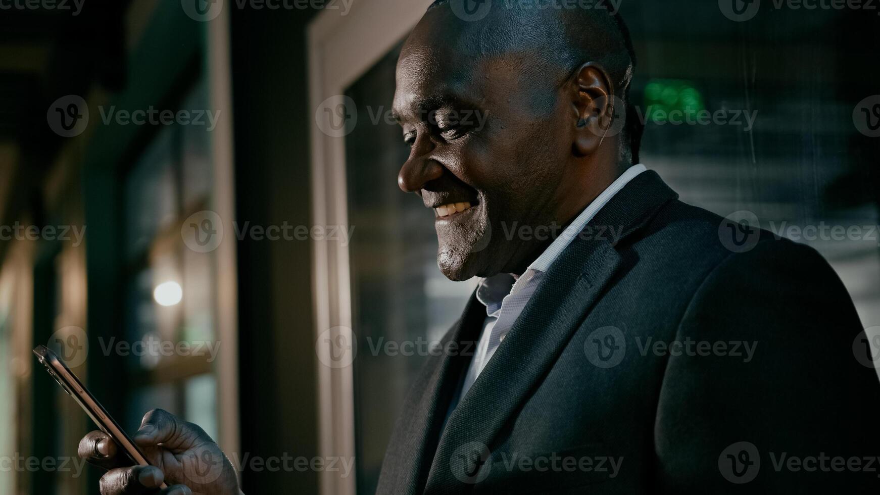Happy smiling mature man holding phone browsing email writing text message uses mobile application satisfied businessman communicates with client on internet talking on call using smartphone photo