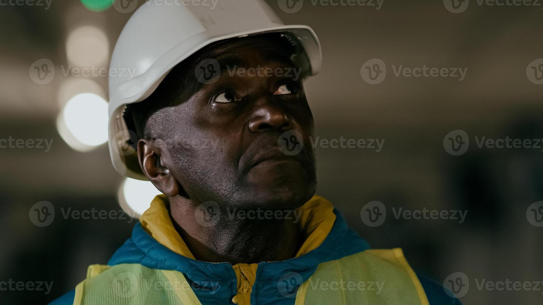 Close-up serious focused mature man professional civil engineer in protective helmet inspects develops plan businessman builder experienced construction worker foreman evaluates planning work process photo