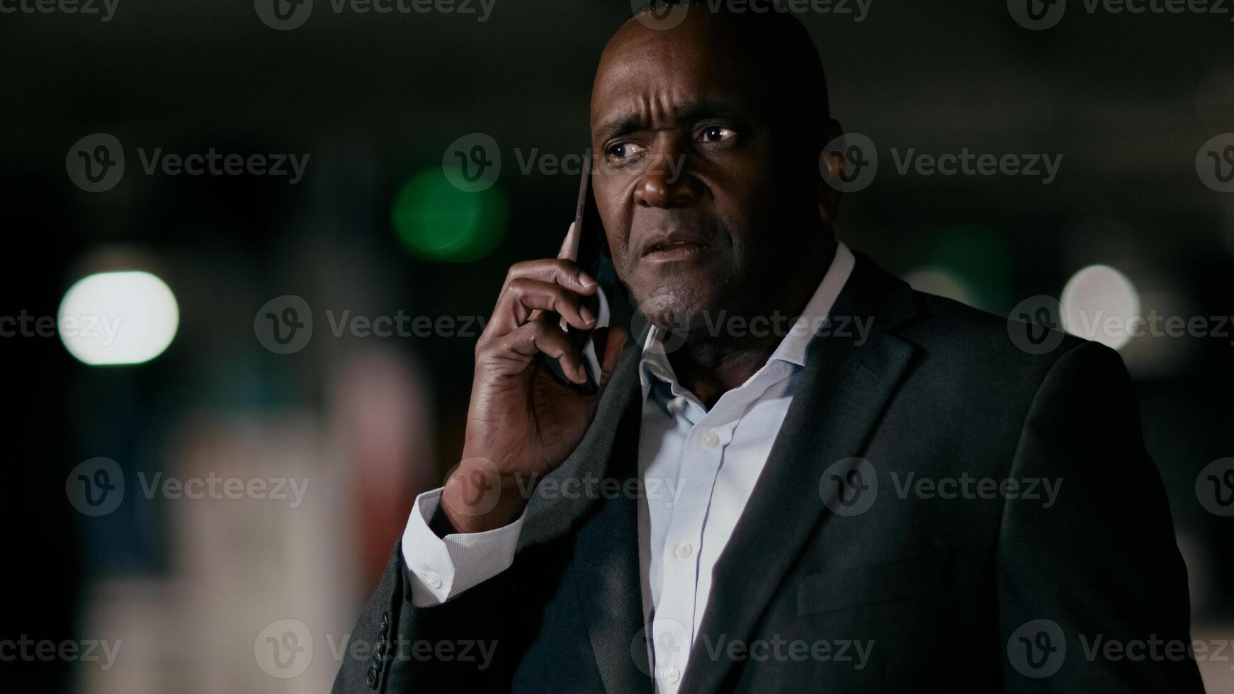 Serious puzzled excited emotional man talking on mobile phone adult worried african american businessman answering business call using smartphone looking around in confusion remotely solves problem photo