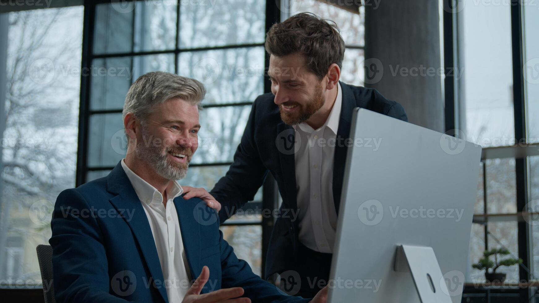 Caucasian man businessman winner look computer monitor screen celebrate victory rejoice success two happy businessmen satisfied winning profitable deal for promotion employee congratulate colleague photo