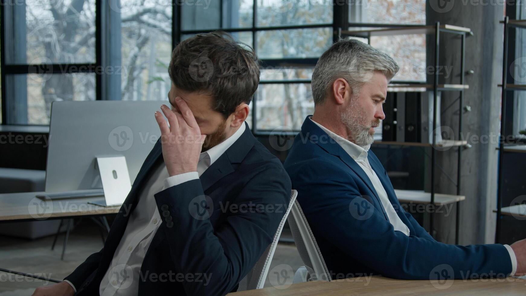 Upset shocked caucasian men businessmen partners employees sitting in office frustrated with business failure think about financial problem depressed entrepreneurs colleagues have trouble feel worried photo