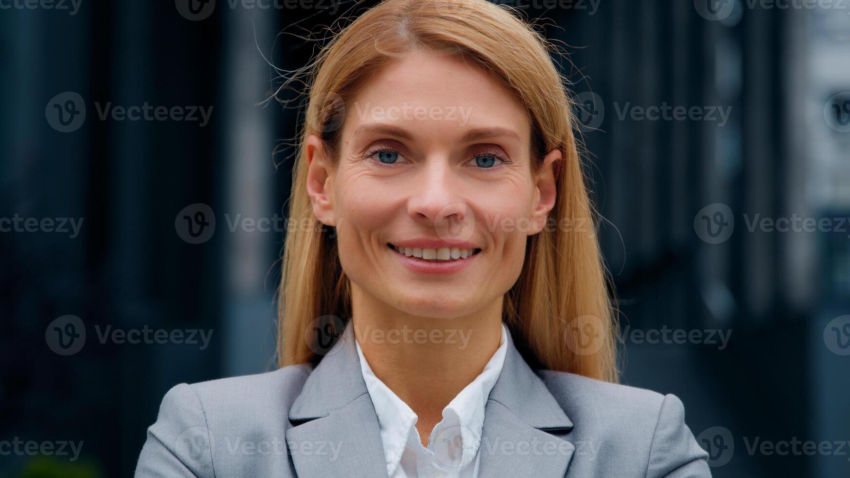 Zooming in on focus close-up female business portrait caucasian beautiful woman model smiling posing outdoors confident successful businesswoman looking at camera happy customer satisfied with service photo