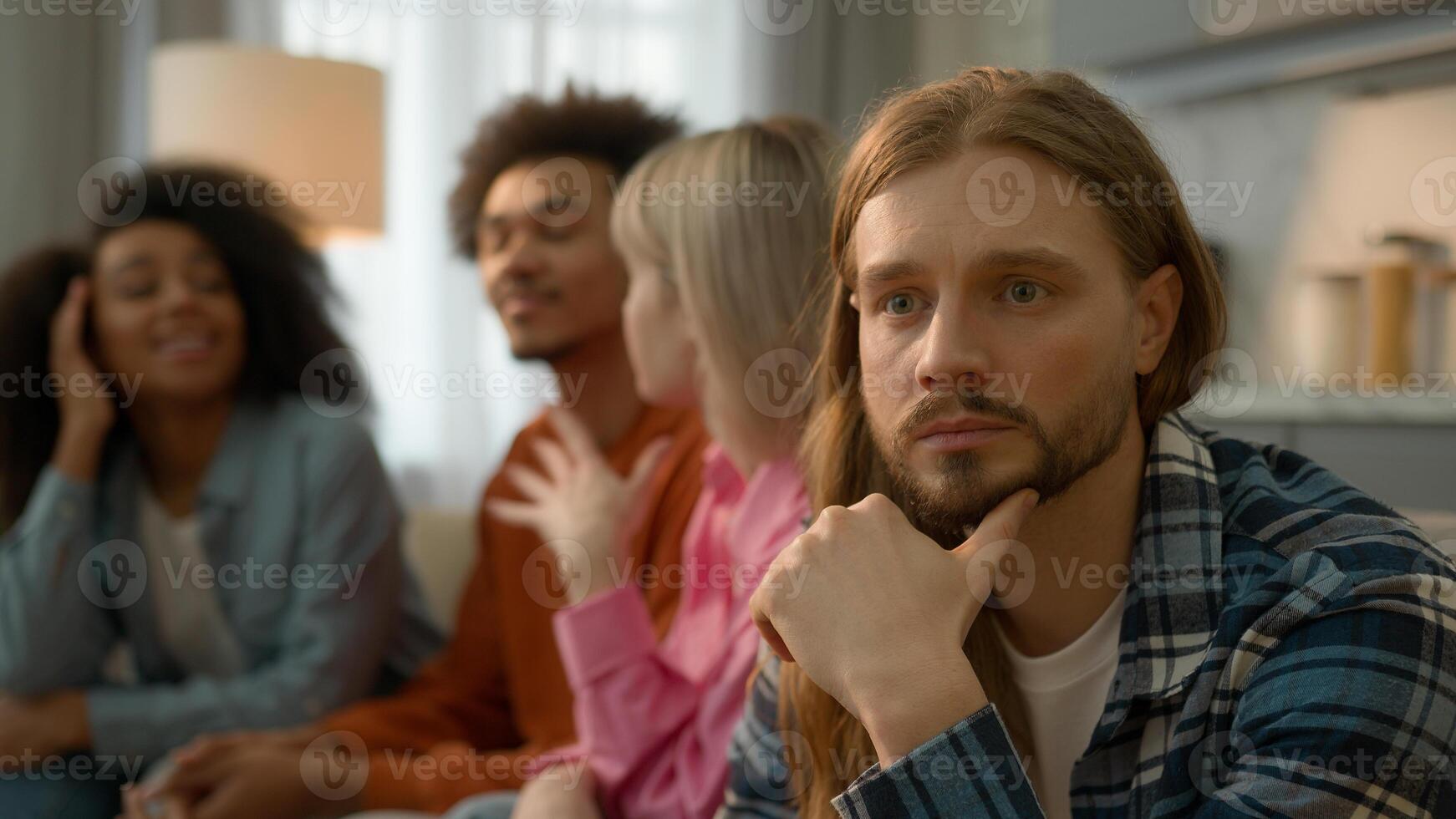 Caucasian sad pensive thinking troubled problem frustrated man guy introvert at home separated ignoring multiracial African multiethnic friends women men laughing talking antisocial outsider male photo