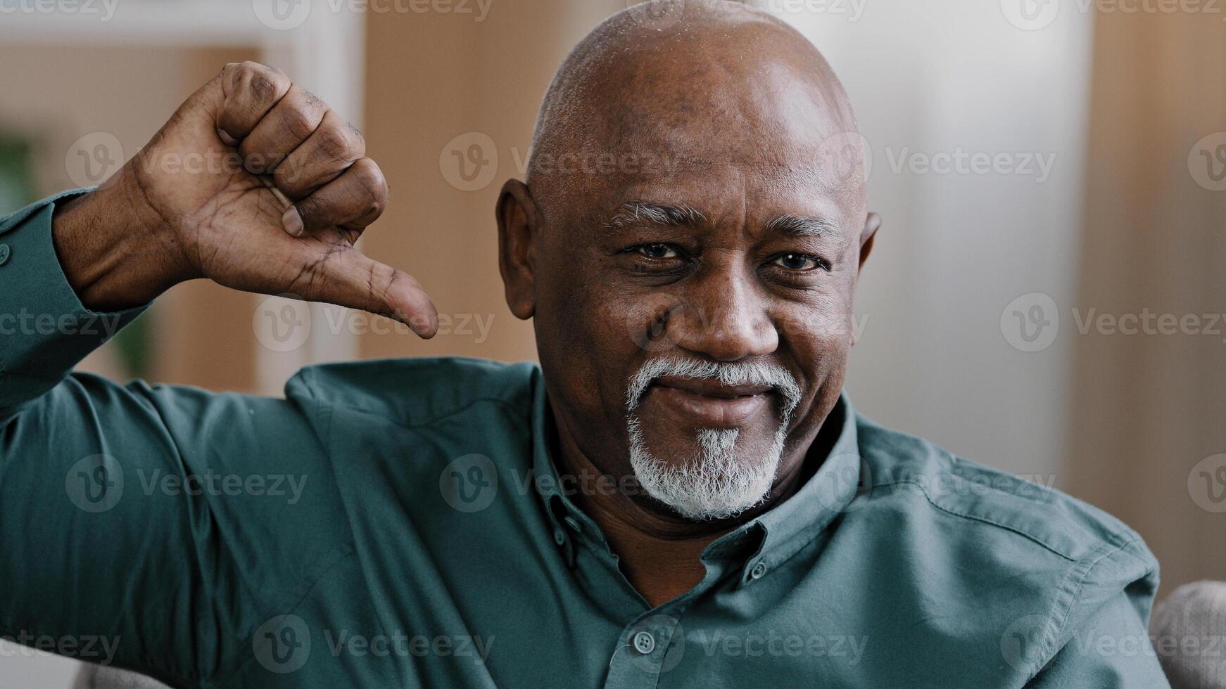 Portrait of confident elderly african american man indoors looking at camera show thumb down negative emotion mature old businessman showing dislike bad attitude disapproval no gesture disagreement photo