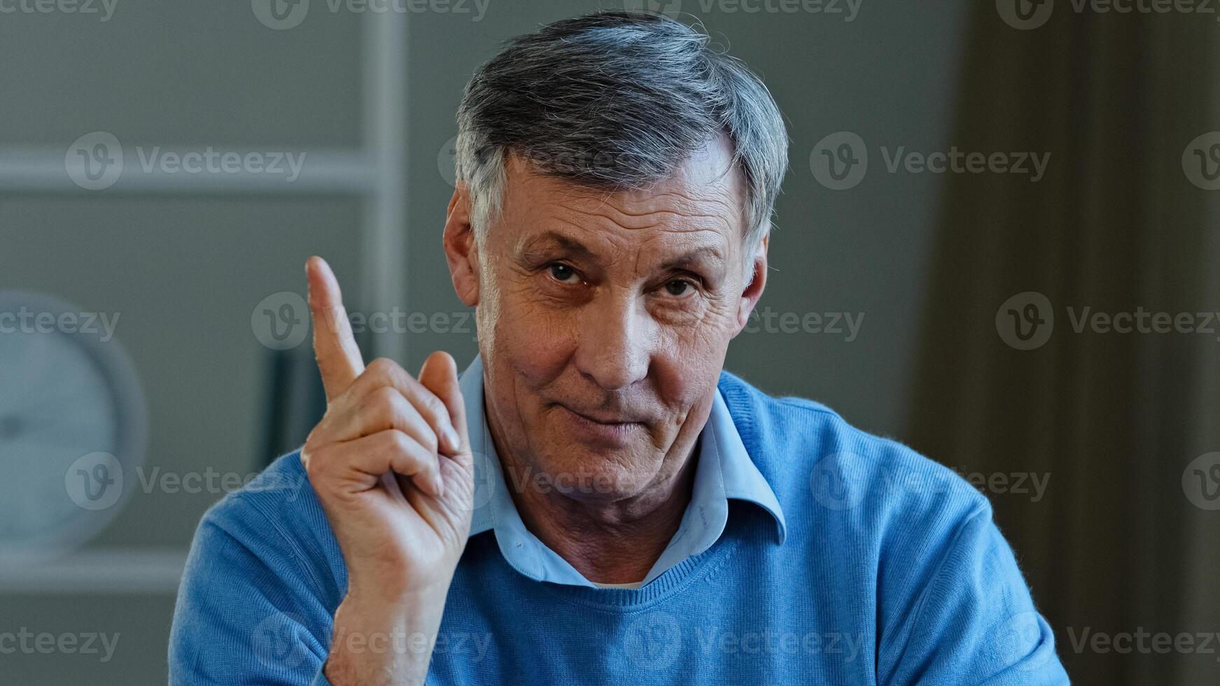 Close-up web cam view online teacher mentor old professor male portrait Caucasian elderly serious man looking camera waving shaking finger scolding explain teaching talking advice distant conversation photo