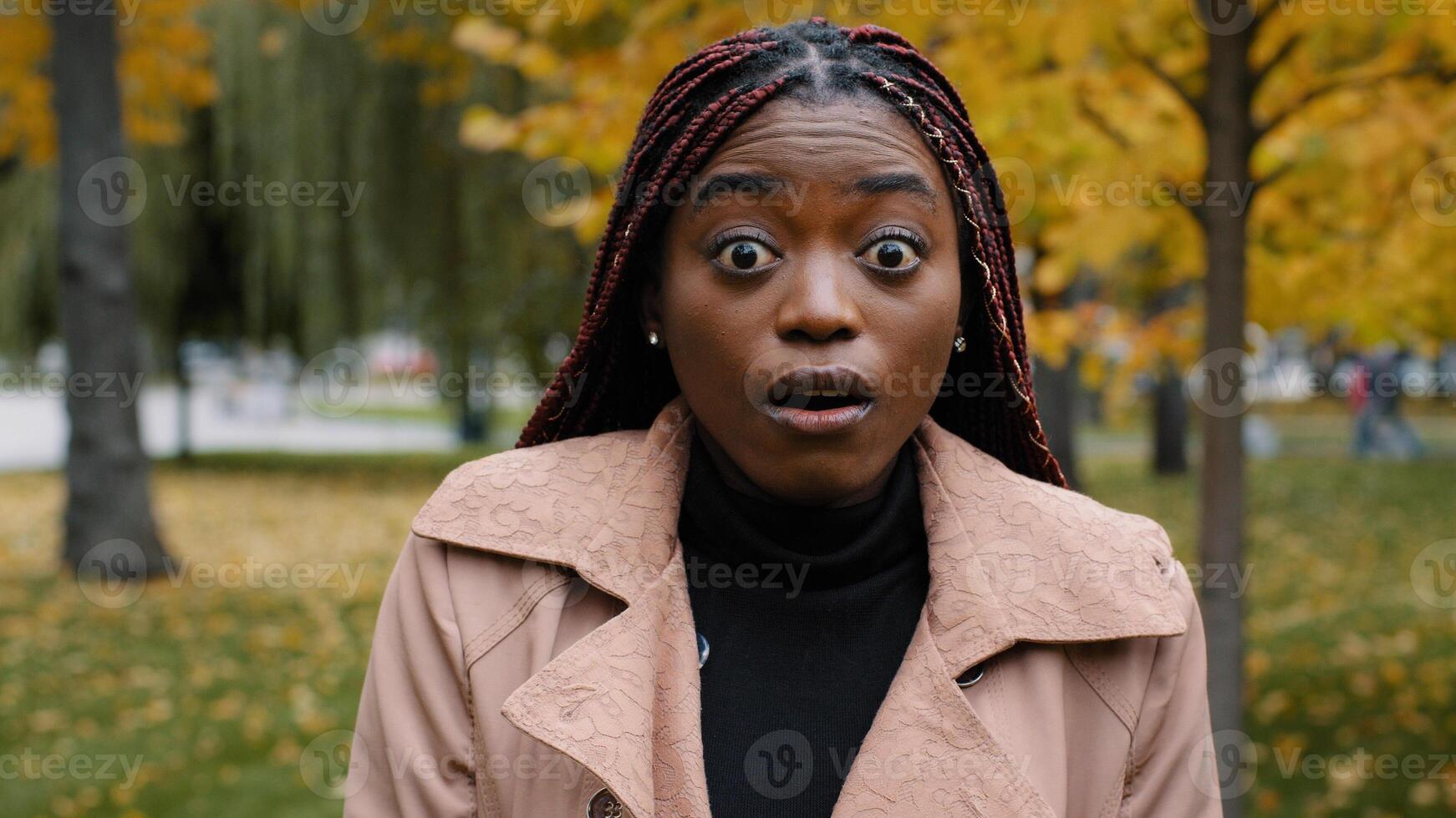 Close-up stunned african american woman standing outdoor looking at camera with eyes wide open and mouth feeling shock surprise from unexpected news amazed young female shocked expression feels wonder photo