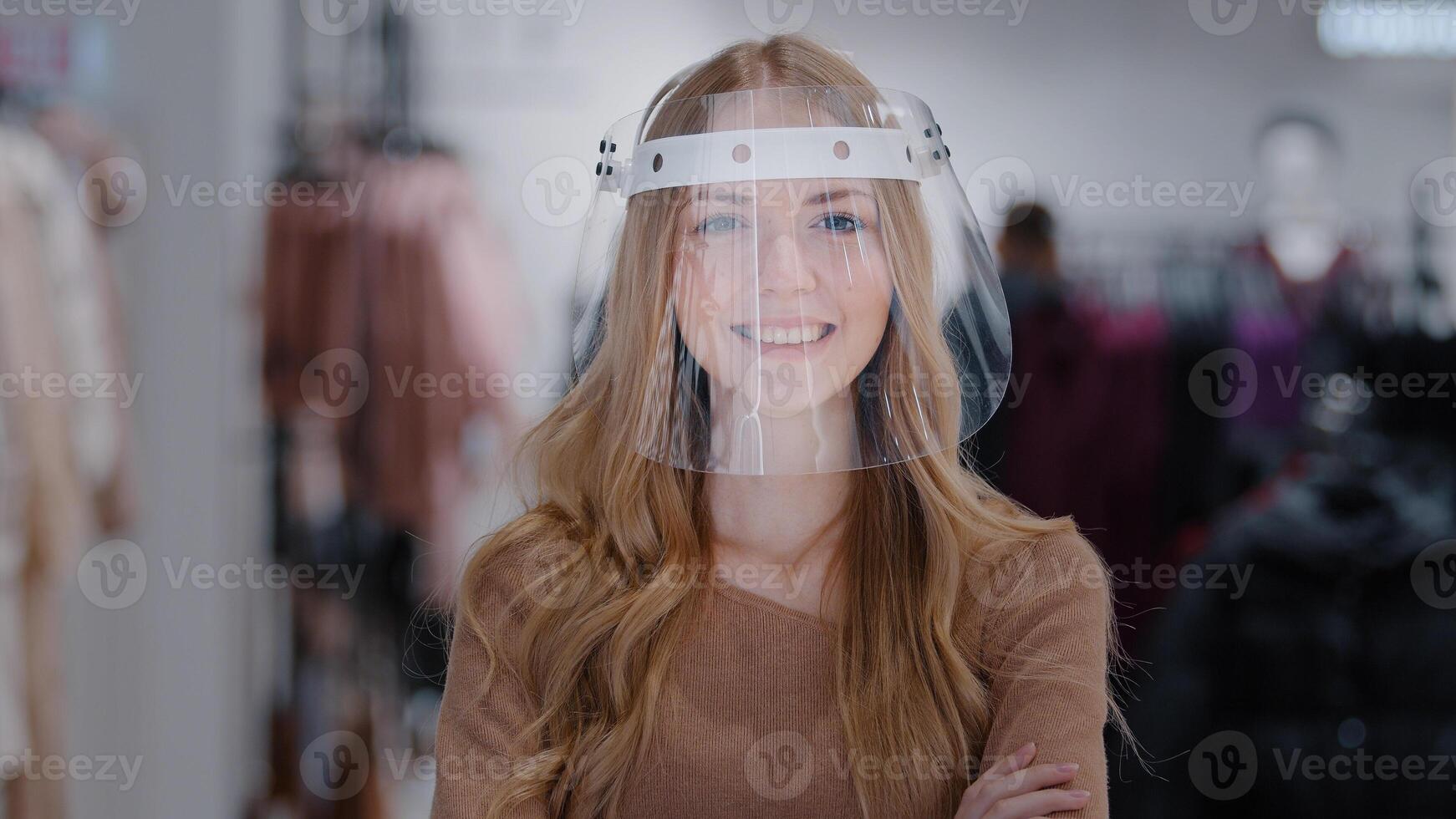 Close-up confident protected store manager girl shop assistant in transparent plastic mask shield portrait woman smiling female buyer looking at camera concept virus spread protection pandemic control photo
