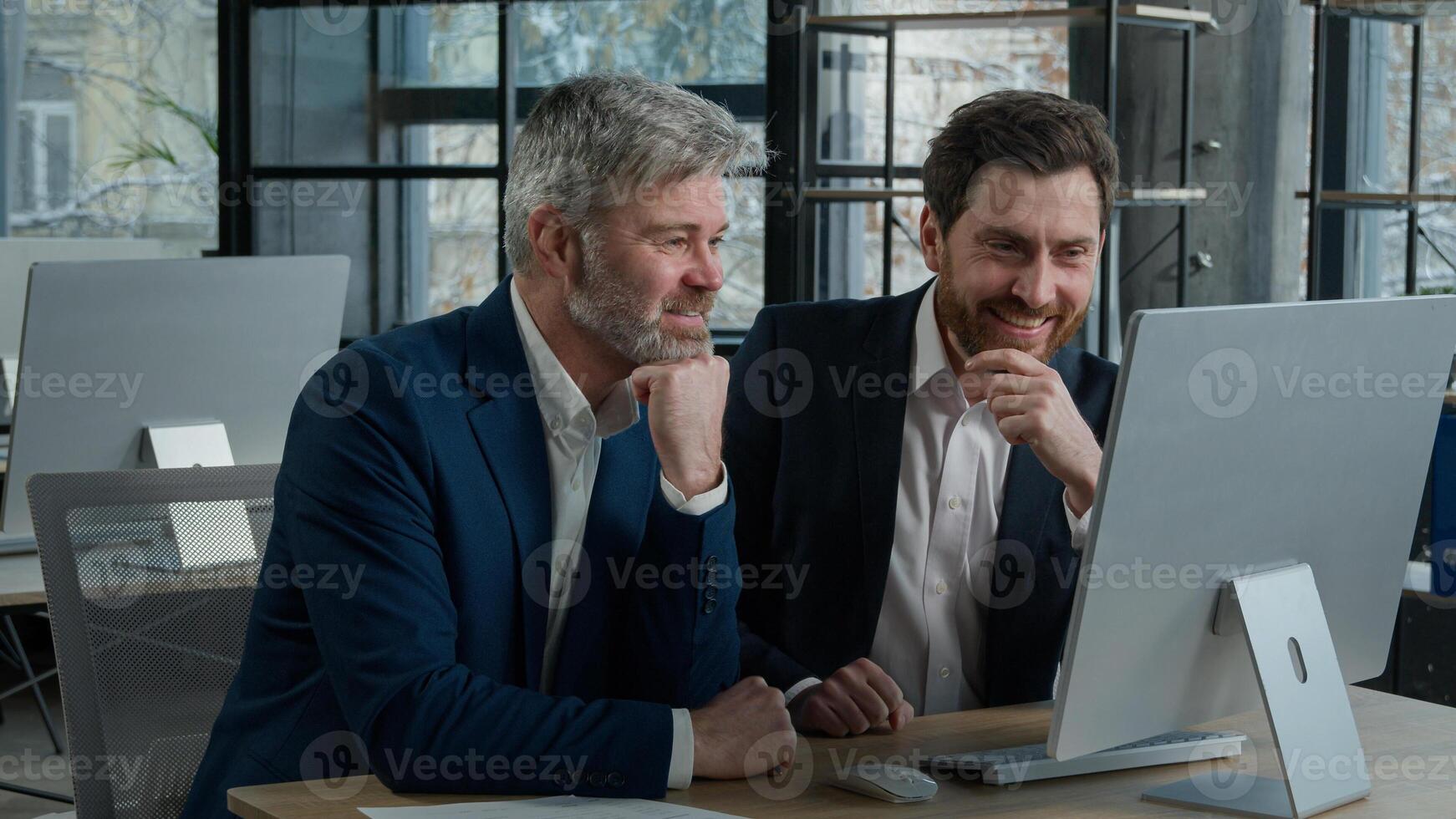 Two surprised happy Caucasian businessmen men business partner employees colleagues looking computer screen celebrating victory win patent rejoicing at achievement successful deal high sales growth photo