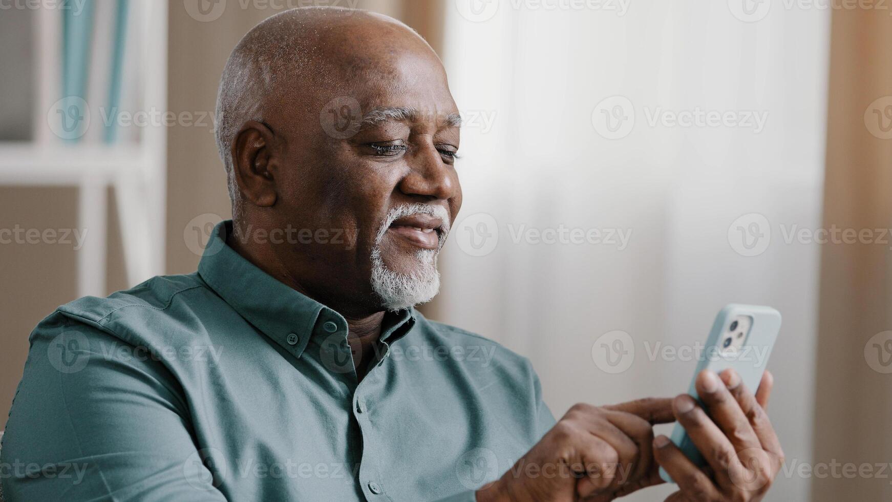 Close up bald American bearded old senior man with gray beard elderly male using software application net on cellphone reading message email swiping browsing online app. smartphone Wi-Fi technology photo