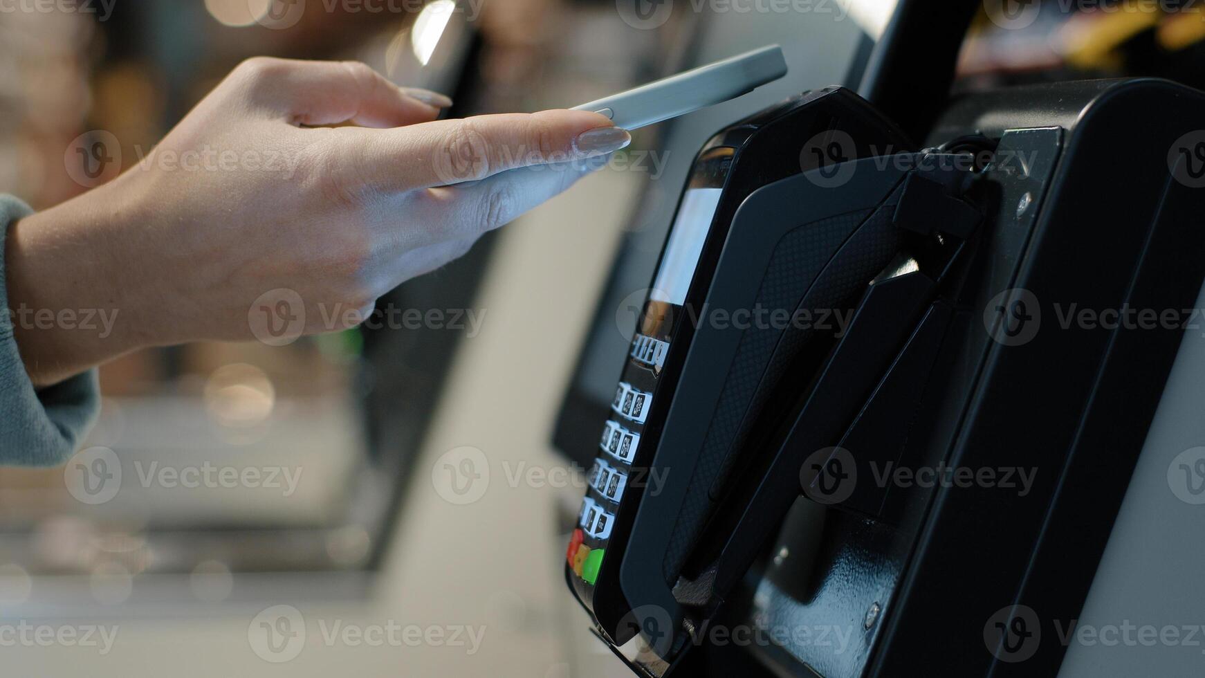 Details female hands paying with phone purchase by cell-phone electronic payment machine card reader e-money concept. Woman client pay smartphone. Pos-terminal buy cashless wifi qr code nfc scan app photo