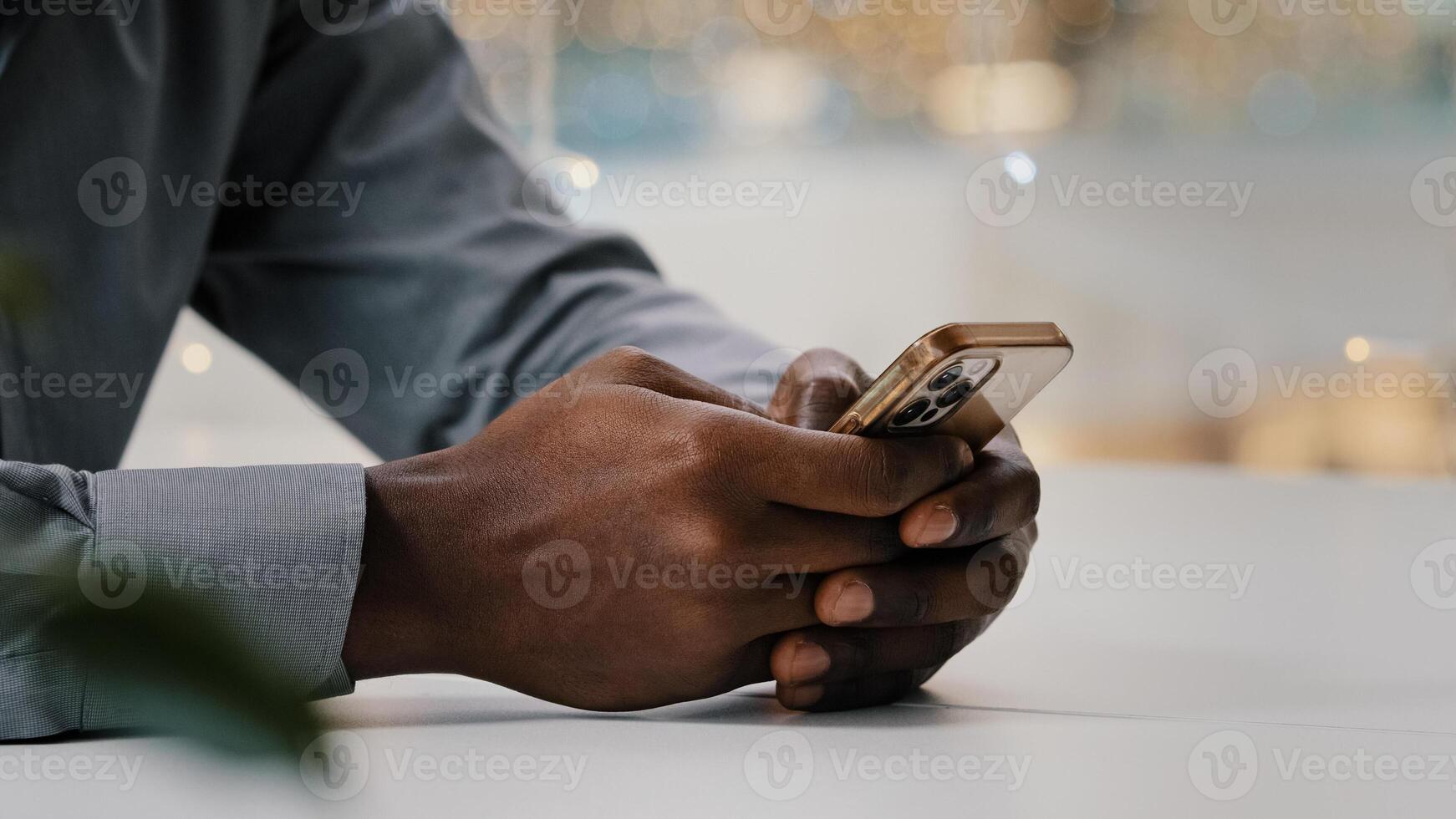 Close-up male hands typing on mobile phone unrecognizable african american businessman checking email working remotely using smartphone young man making order in online store browsing social network photo