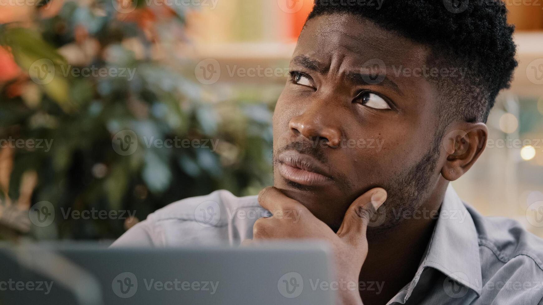 Close-up serious pensive male student freelancer thinks over project young puzzled businessman searching solution problem deep in thought remembers finds idea smiling enthusiastic typing on laptop photo