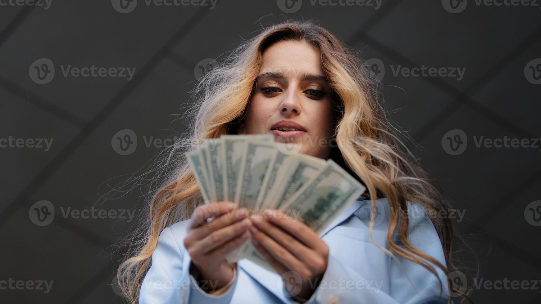 Bottom view successful rich girl business woman buyer holding banknotes dollars in hands counting money salary credit finance thinking holds chin with hand thoughtfully thinks about investment profit photo