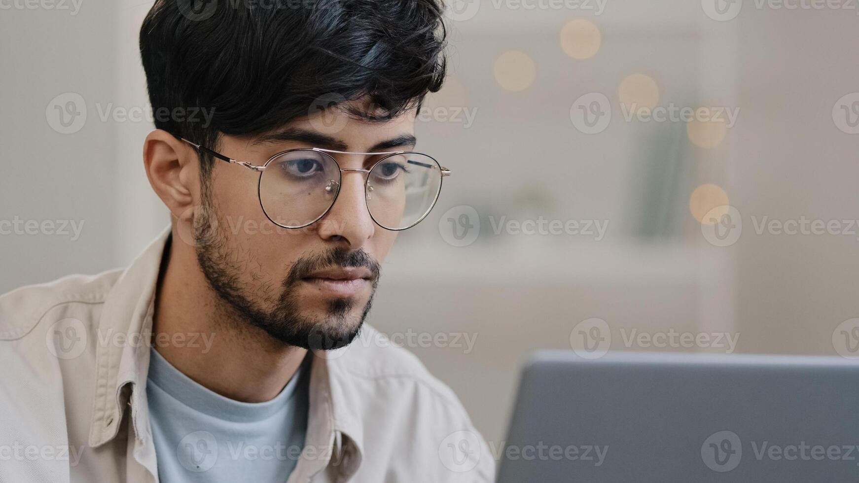 Close-up male face arabic hispanic man bearded guy working with laptop feels stress suffering from headache takes off glasses rubs eyes worried about business problems pressure migraine difficult task photo