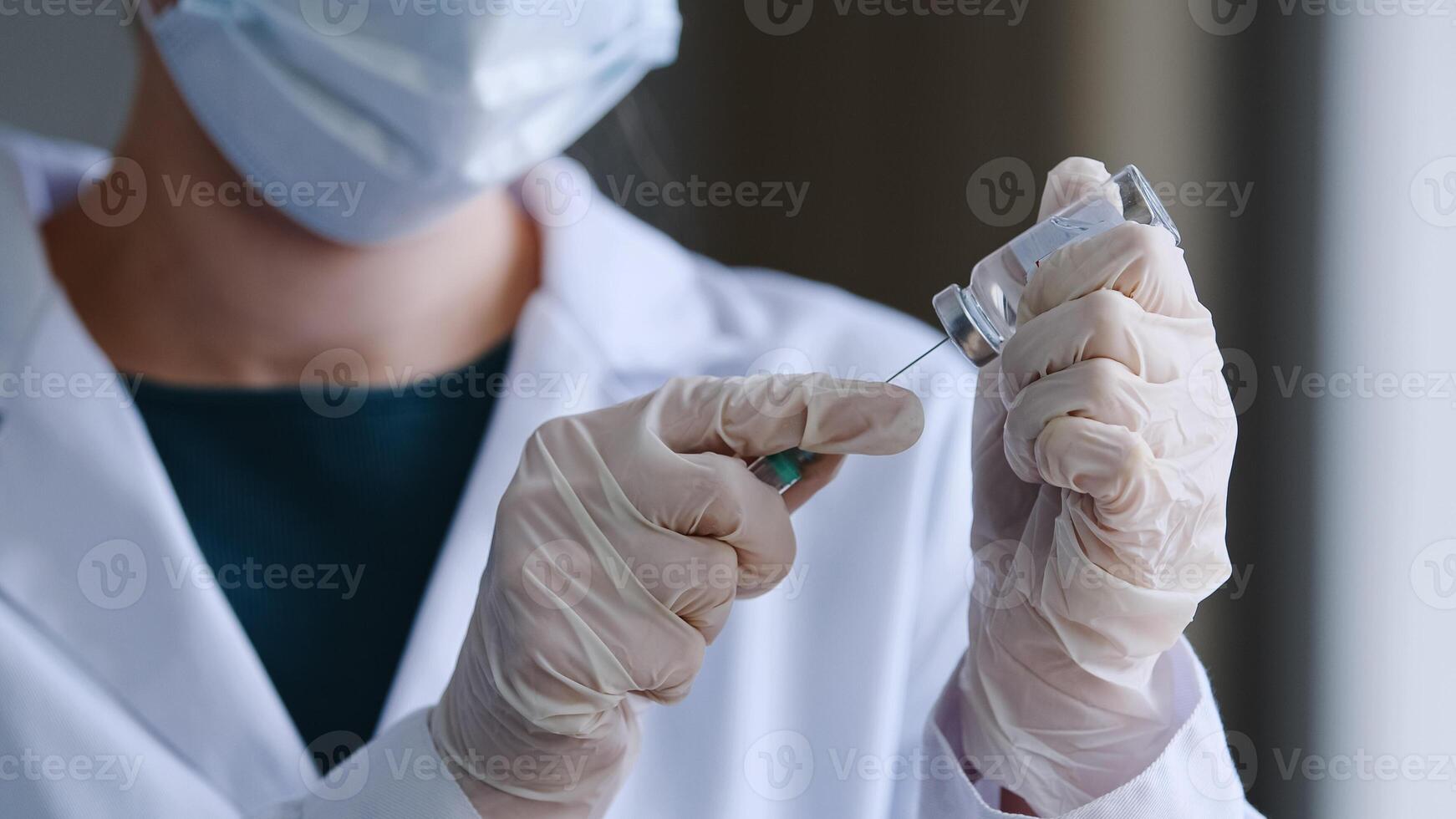 de cerca hembra manos en látex guantes de irreconocible mujer médico enfermero en protector máscara diales líquido medicina antibiótico vacuna coronavirus remedio en jeringuilla preparar para inyección vacunación foto
