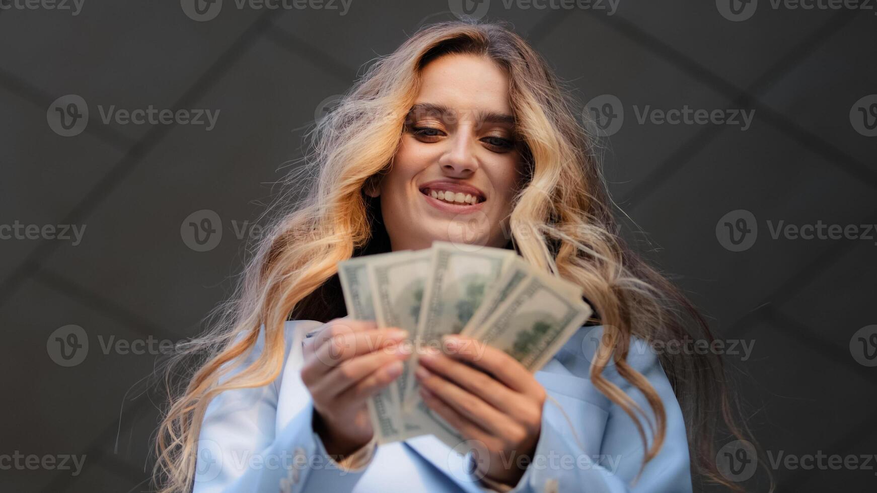 Bottom view close up happy successful caucasian young business woman checking amount of cash money dollars counting finance salary rejoice with payment. Smiling girl holding hundred bill banknotes photo