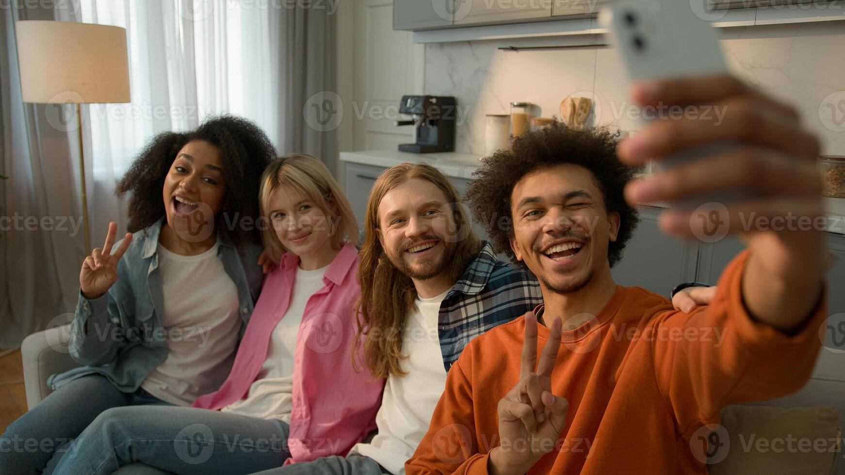 Group of multiracial people multiethnic friends Caucasian girls African American female women guys male men together posing on couch home sofa make selfie photo with mobile phone influencer blogger