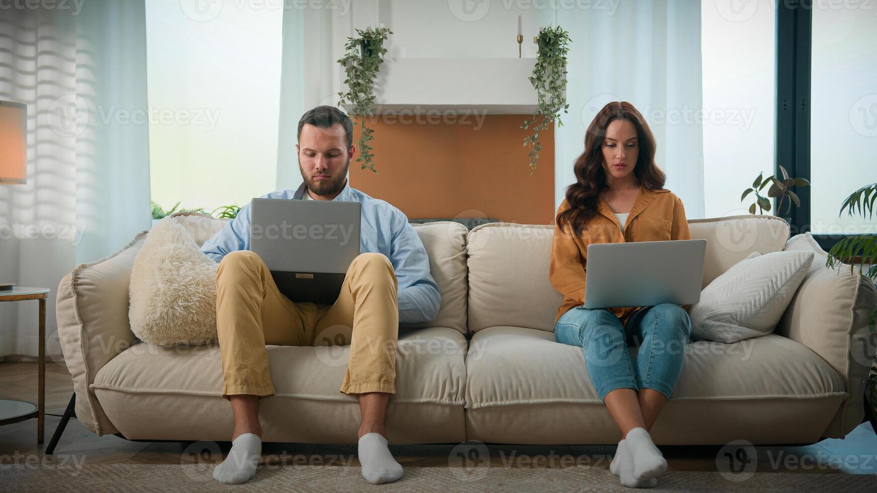 Focused busy stressed Caucasian man woman working freelance remote internet on laptop at home online business noisy naughty boy child son distract parents dad mom from work need attention bad behavior photo