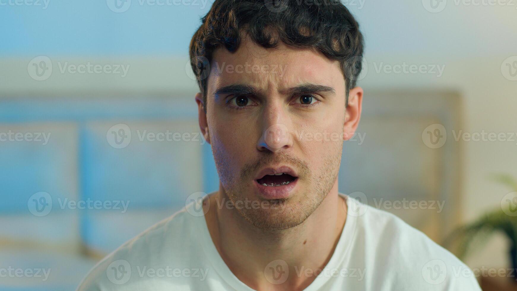 Close up face young Caucasian European man disgust misunderstanding rejection squint frowning confused reaction displeased portrait expression negative frustrated gesture feeling home bedroom indoors photo