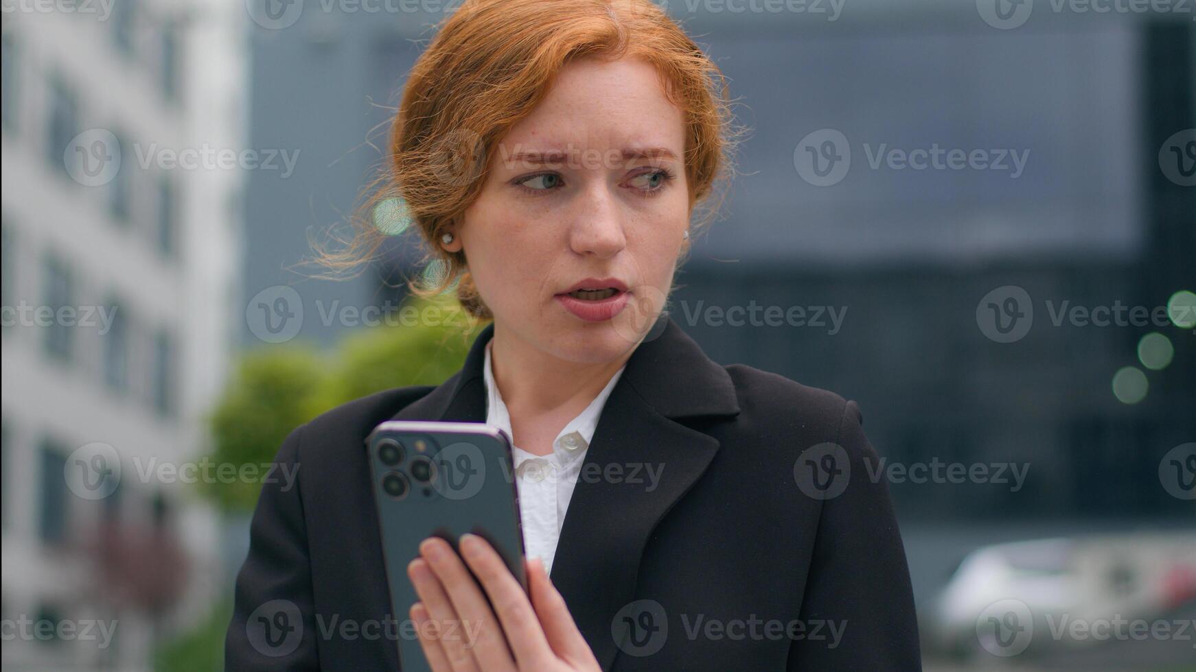 Nervous sad Caucasian redhead businesswoman female girl woman student worker entrepreneur using mobile cell phone cry anxious fired job problems receive failed exam results losing outside city street photo