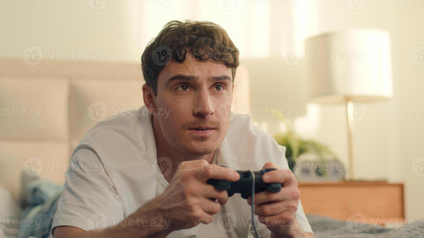 Upset man playing game joystick loss male bedroom bed failure mistake displeased annoyed dissatisfied sad unhappy championship technology struggle defeat gamer electronic cyberspace challenge photo