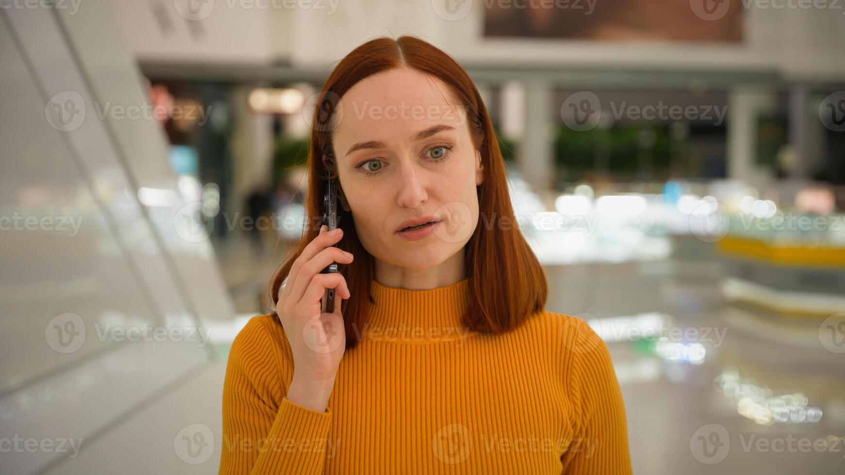 Successful serious worried young girl client Caucasian businesswoman female saleswoman customer woman speaking mobile phone cellphone conversation call talk solve business problem shopping mall store photo