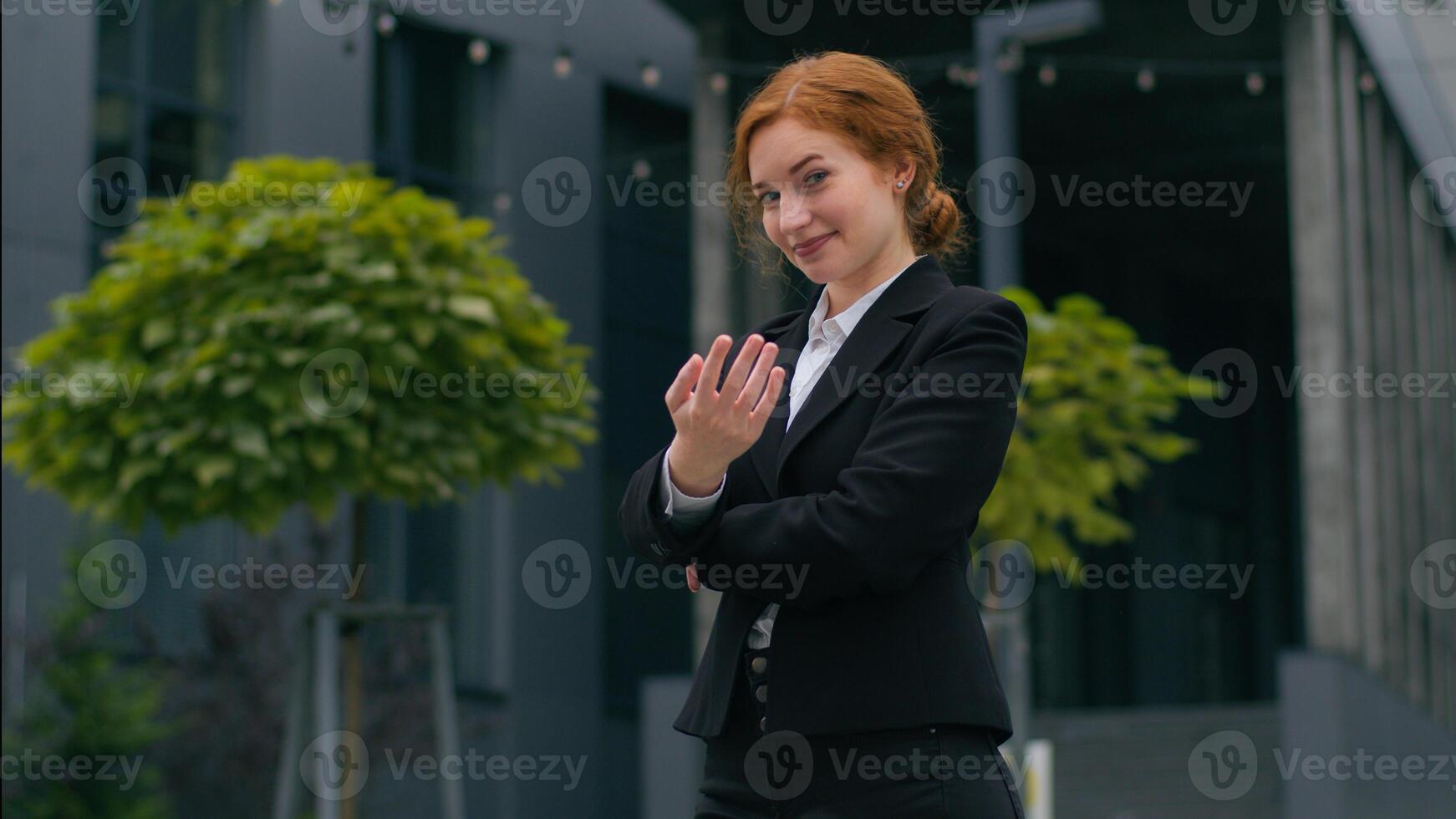 Happy friendly smiling young Caucasian ginger businesswoman recruiter girl female woman crossed arms formal suit welcome invite wave hand welcoming join invitation gesture outside city office building photo