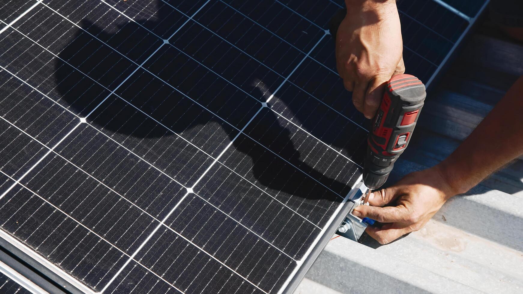 Connection and installation of solar panels. Workers attach solar panels. Technicians install solar panels on a metal stand. Workers install photovoltaic solar panels on the roof of a house photo