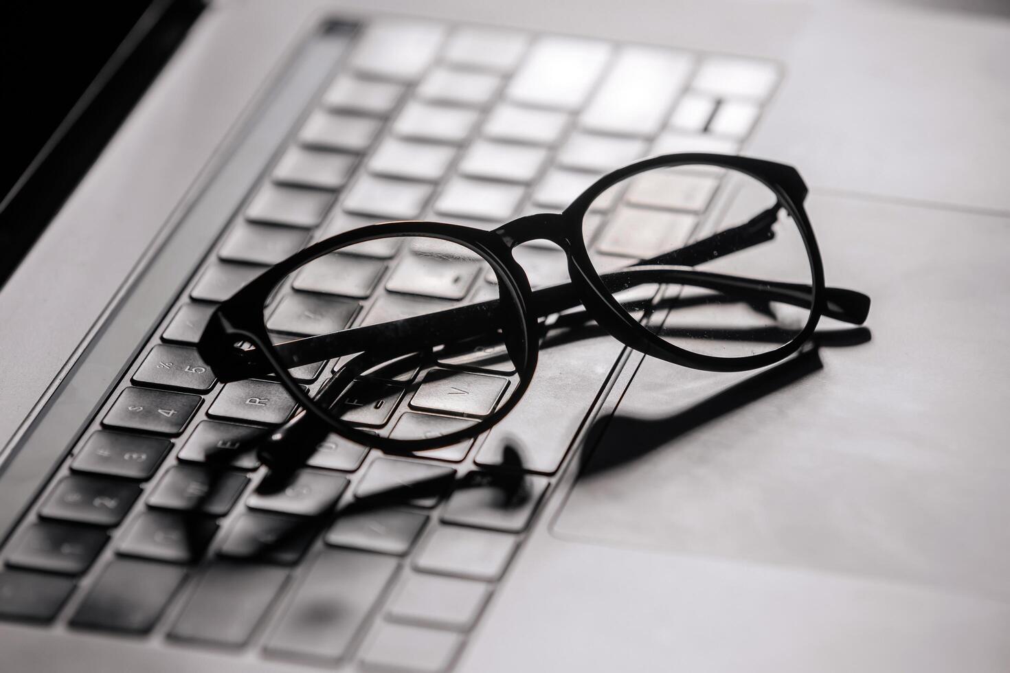 Sleek eyewear placed on a laptop keyboard, highlighting the importance of tech solutions for digital eye care. Perfect for frequent computer users photo