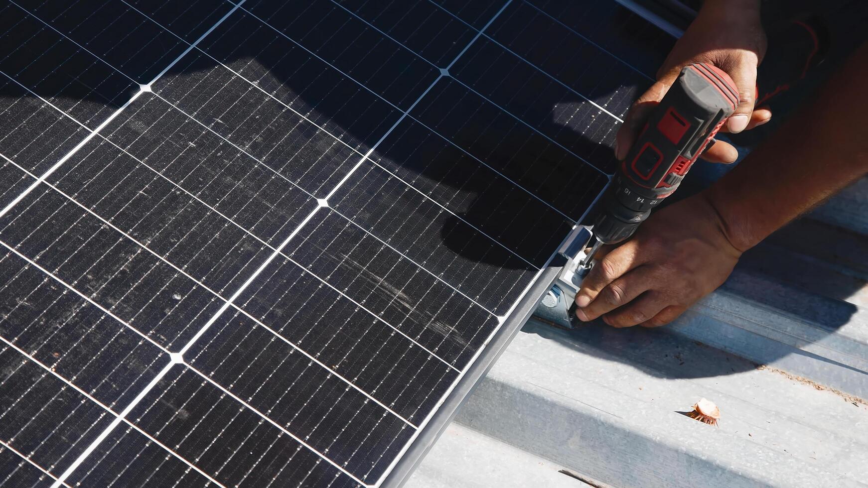 Connection and installation of solar panels. Workers attach solar panels. Technicians install solar panels on a metal stand. Workers install photovoltaic solar panels on the roof of a house photo
