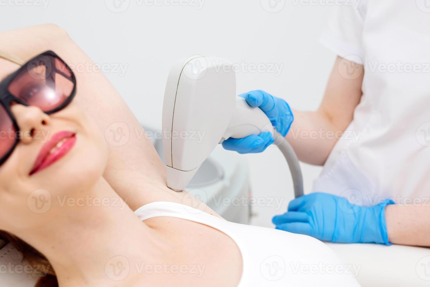 Laser hair removal for underarms in a professional beauty clinic. A skilled technician performs the procedure to ensure smooth and hair-free skin photo