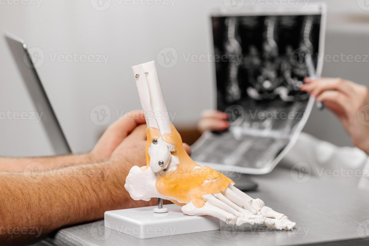 A doctor in a white coat provides expert advice on ankle joint conditions, using a detailed model for clear patient understanding. Perfect for medical consultations and educational content photo