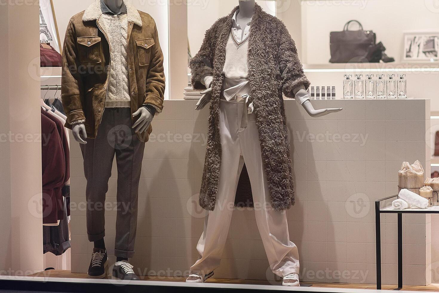Female and male mannequins fashionable clothes of the autumn collection on the window display of a luxury store photo