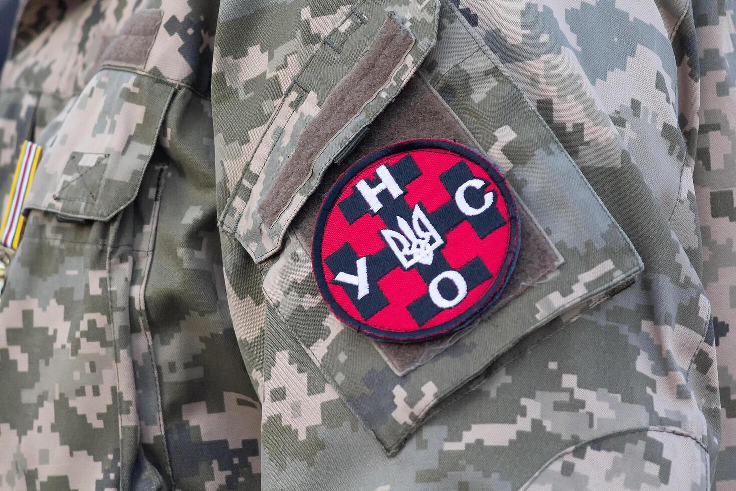 Chevron of the nationalist party Ukrainian nano self-defense on the shoulder of a Ukrainian military man photo