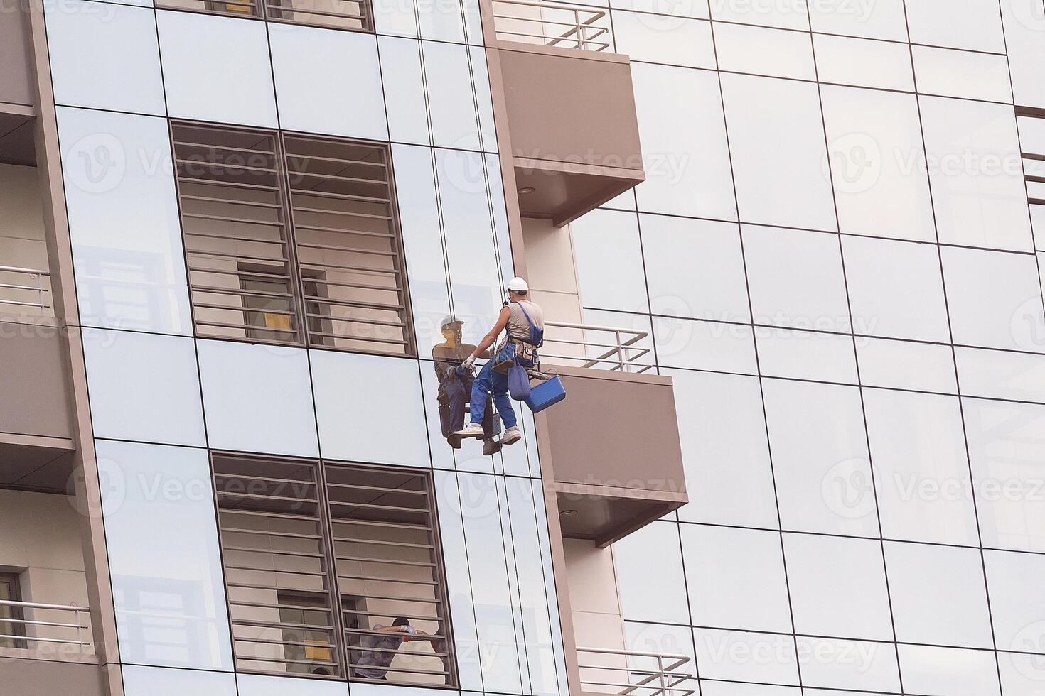 Climber wash windows and glass facade of the skyscraper photo