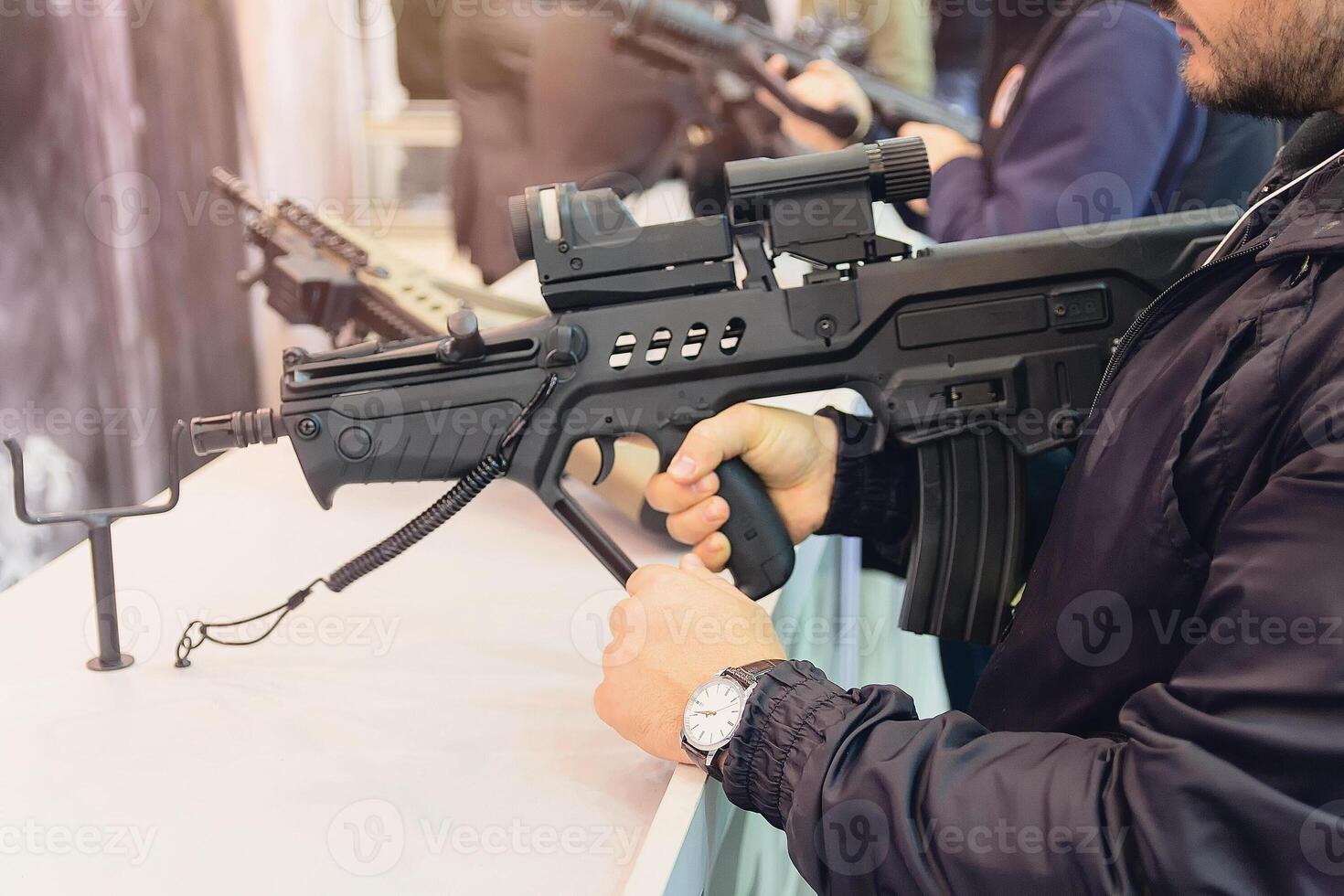 Buyer selects an automatic rifle in a gun store photo
