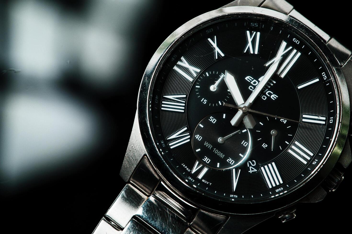 a close up of a silver watch with roman numerals photo