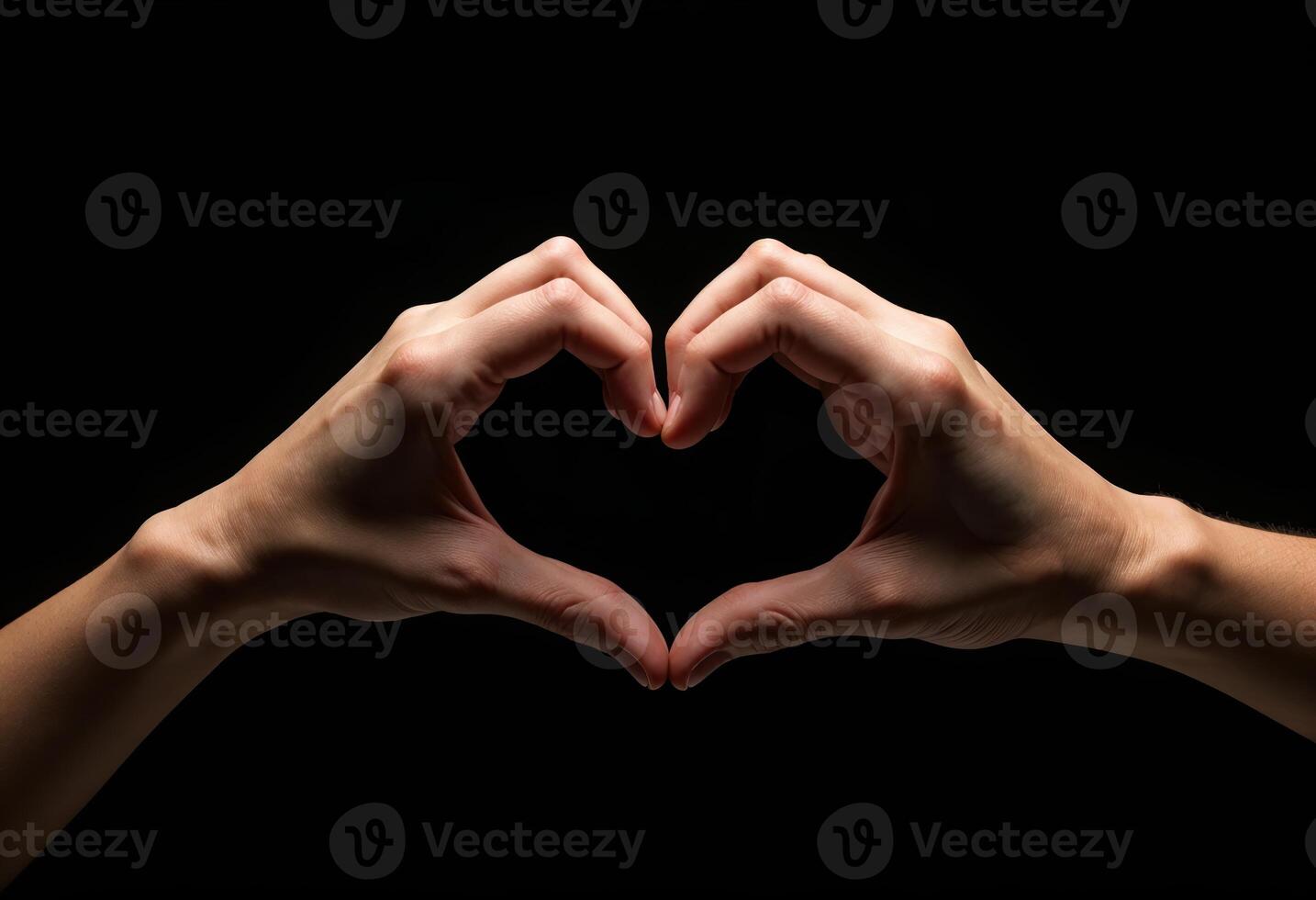 Hands gesture forming heart shape on black background photo
