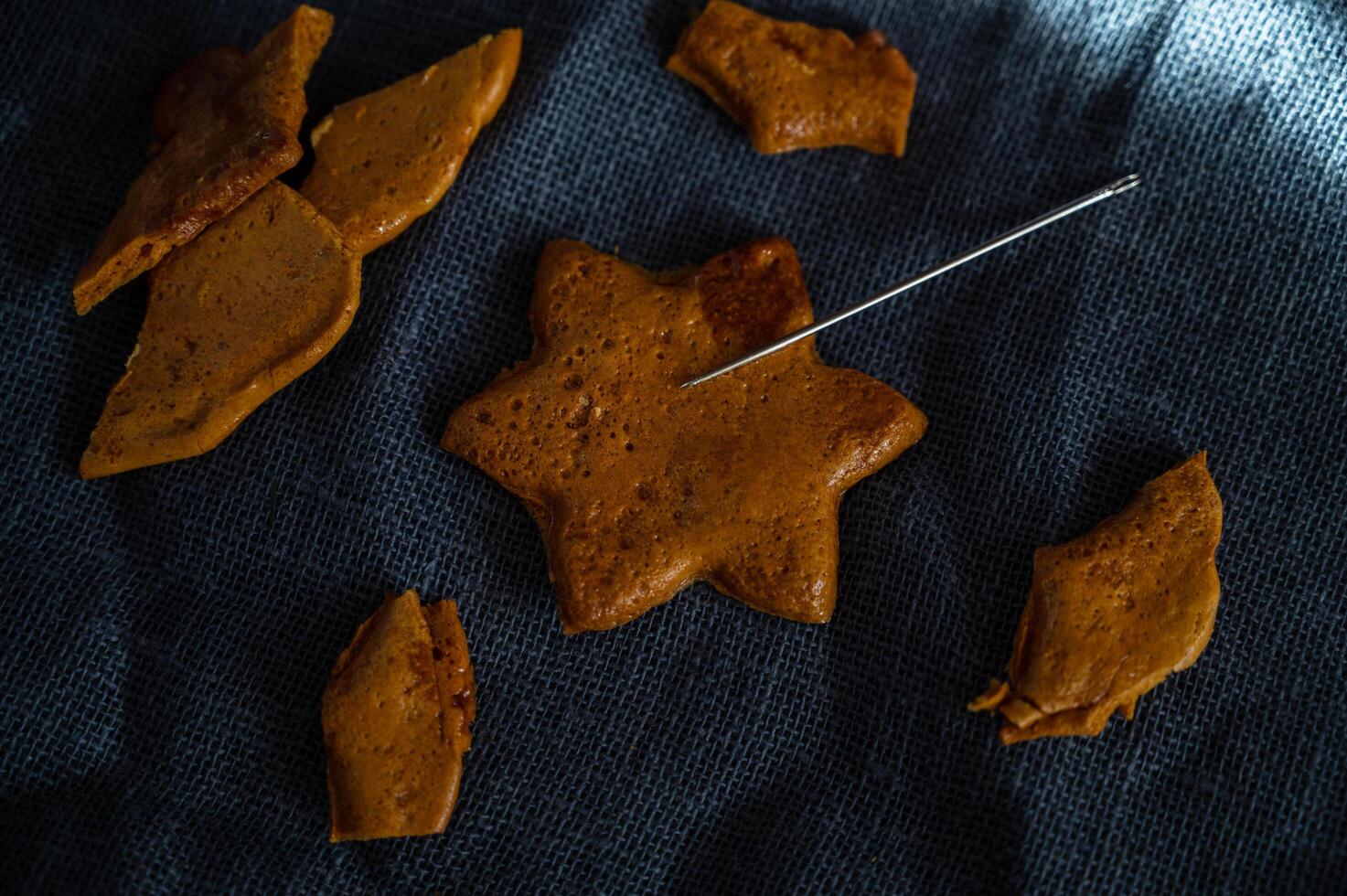 Broken Brown sugar caramel candy cookies with a metal needle photo
